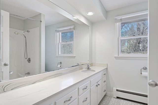 bathroom featuring baseboards, baseboard heating, vanity, and tile patterned flooring