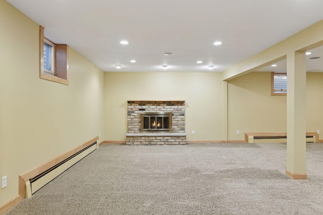 finished basement featuring recessed lighting, a brick fireplace, carpet, and a baseboard radiator