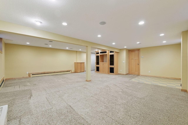 finished below grade area with recessed lighting, a baseboard heating unit, light carpet, and baseboards