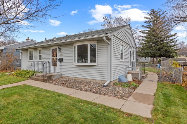 bungalow-style home with a front yard and fence