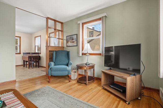 sitting room with baseboards and wood finished floors