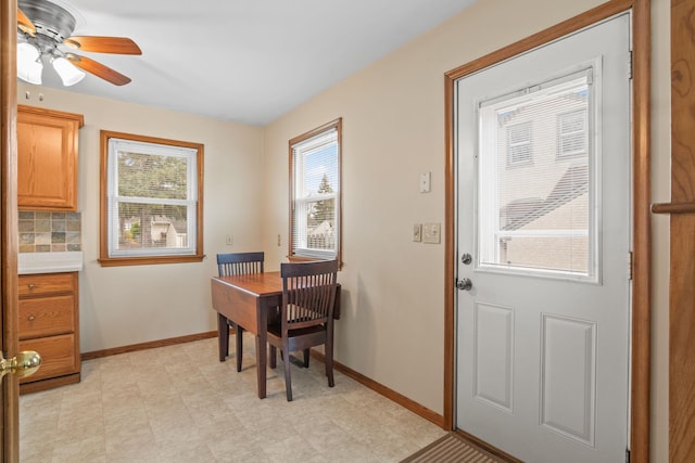 dining space with baseboards and a ceiling fan