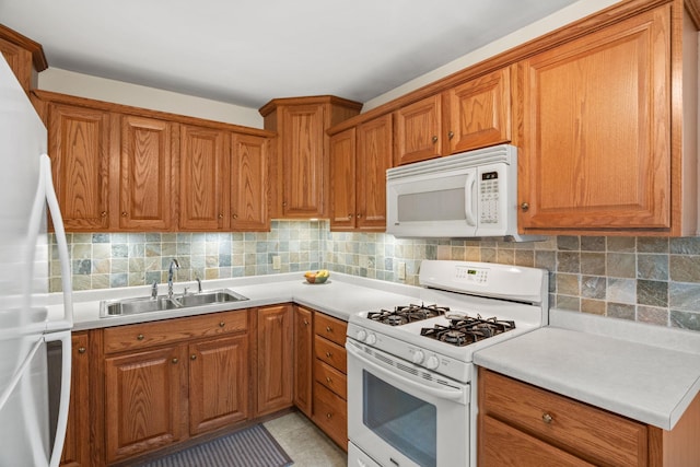 kitchen with white appliances, a sink, and brown cabinets