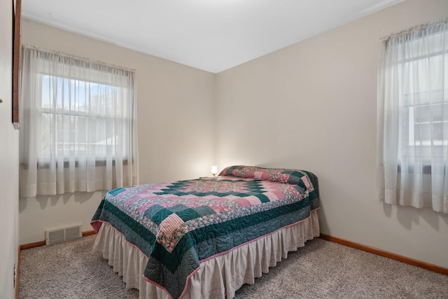 carpeted bedroom with visible vents and baseboards