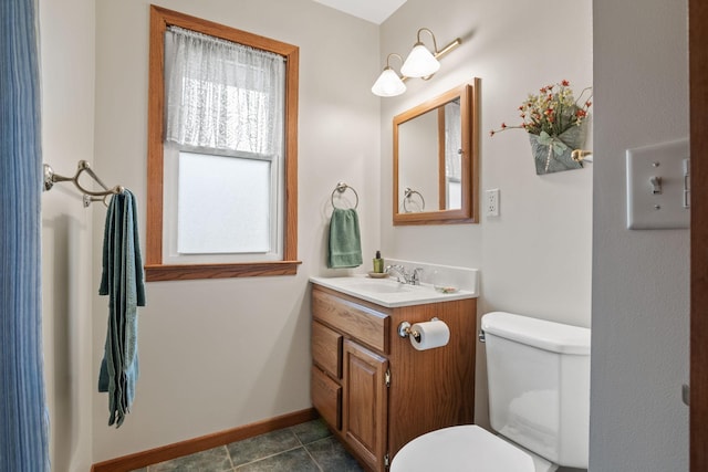 bathroom with baseboards, vanity, toilet, and tile patterned floors