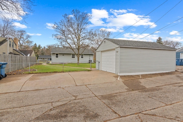 detached garage featuring driveway and fence