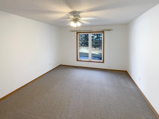 carpeted spare room with ceiling fan, a textured ceiling, visible vents, and baseboards