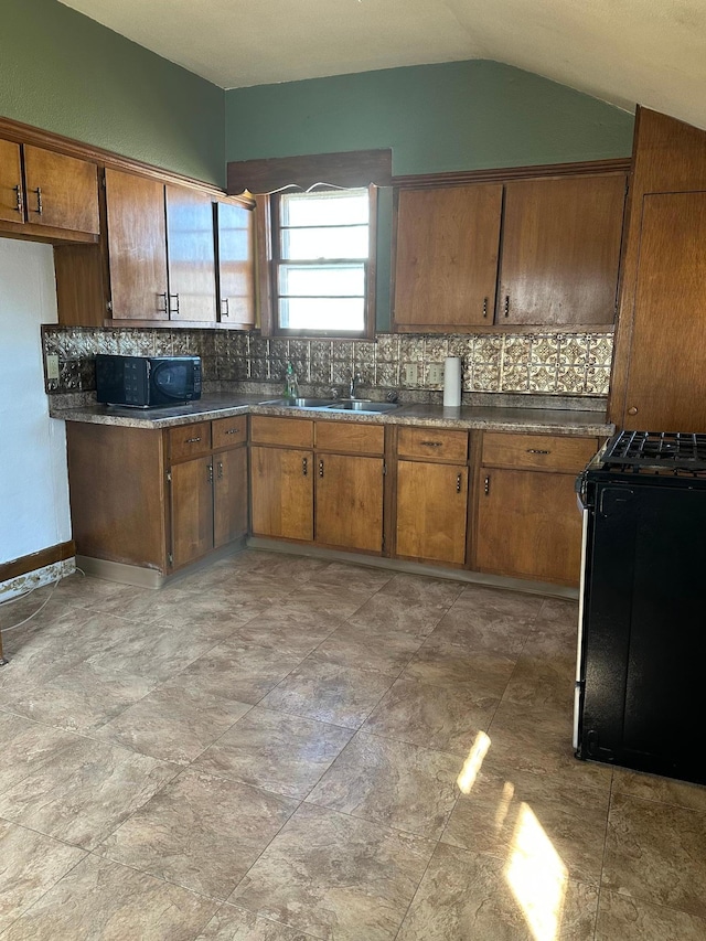 kitchen with tasteful backsplash, dark countertops, black microwave, and gas stove