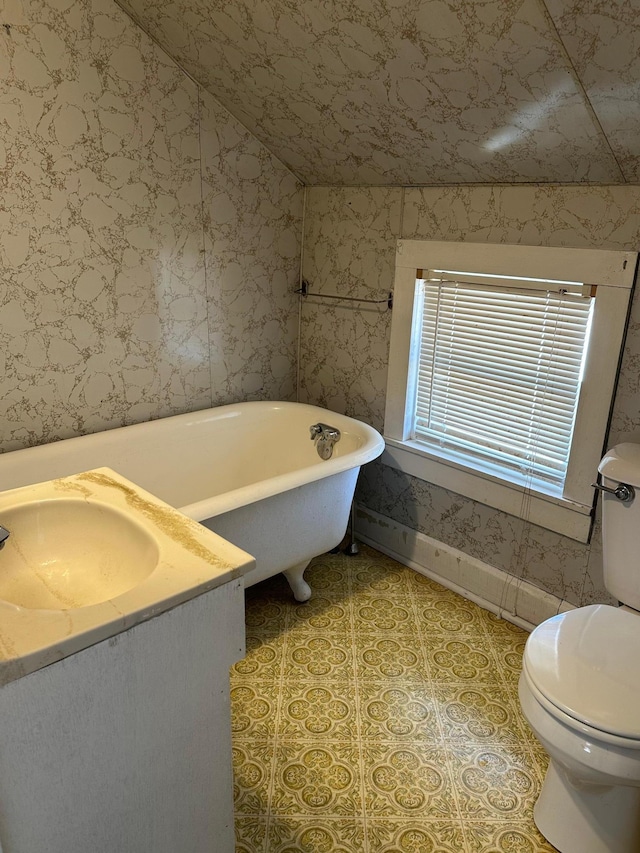 bathroom featuring a soaking tub, toilet, vaulted ceiling, a sink, and wallpapered walls