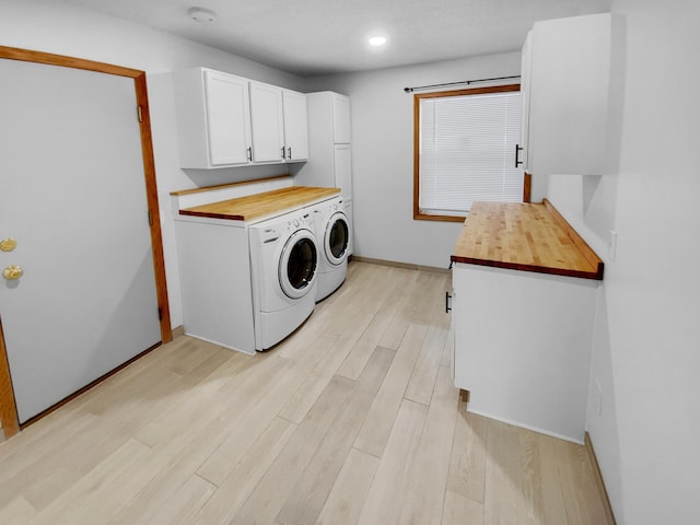 laundry area with cabinet space, baseboards, light wood-style flooring, washing machine and clothes dryer, and recessed lighting