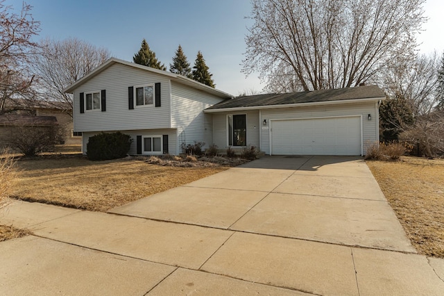 tri-level home featuring an attached garage and concrete driveway