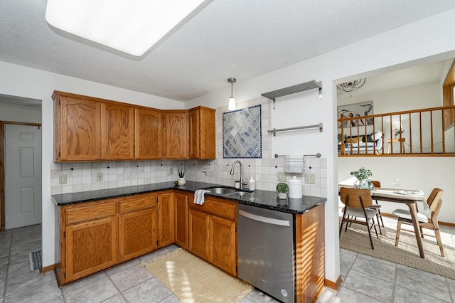 kitchen featuring stainless steel dishwasher, brown cabinets, and a sink