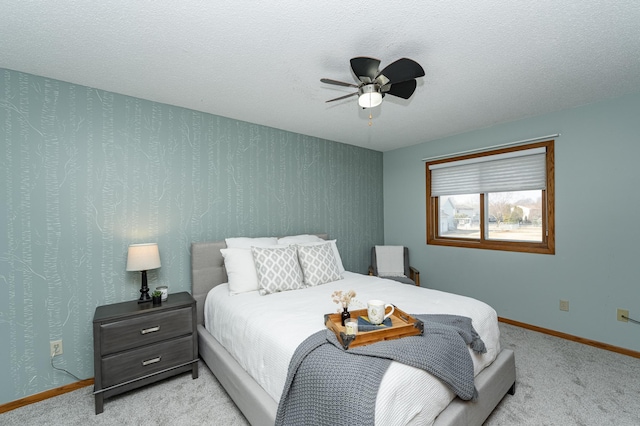 bedroom featuring wallpapered walls, ceiling fan, baseboards, carpet flooring, and a textured ceiling