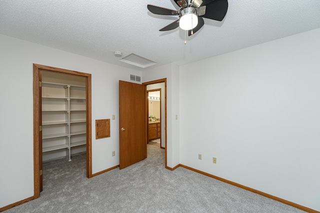 unfurnished bedroom with visible vents, a textured ceiling, a closet, baseboards, and a spacious closet