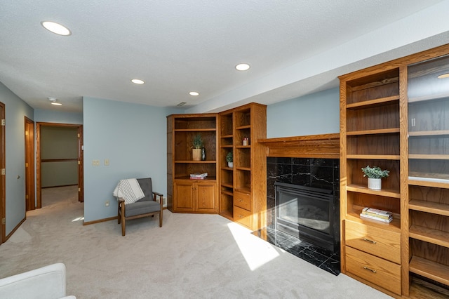 living area featuring recessed lighting, baseboards, light carpet, and a fireplace