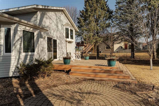 rear view of house with a wooden deck, fence, and a patio area