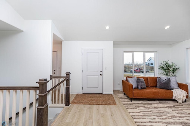 foyer entrance featuring baseboards, wood finished floors, and recessed lighting
