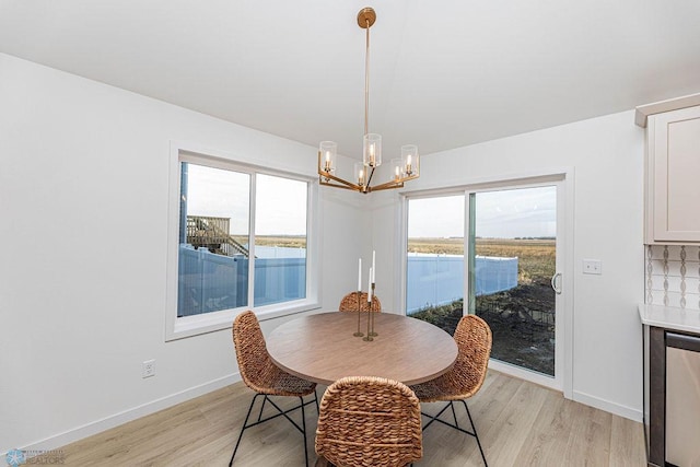 dining space with an inviting chandelier, light wood-style flooring, and baseboards