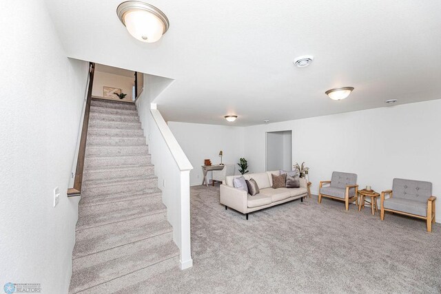 living room featuring stairway and carpet flooring
