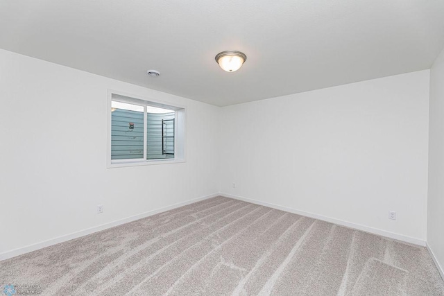 carpeted spare room featuring baseboards