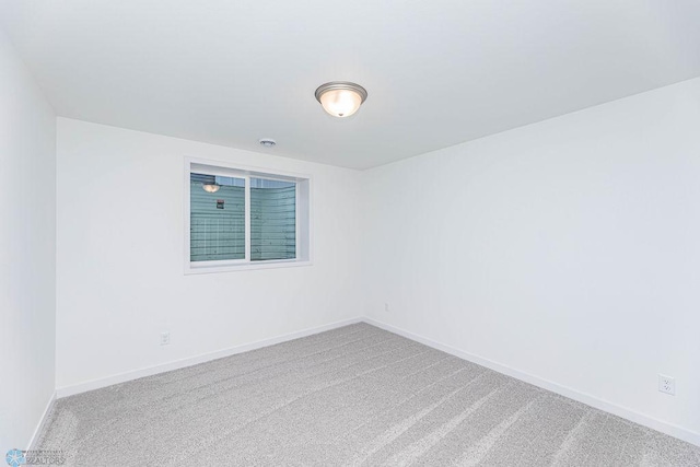 unfurnished room featuring carpet floors and baseboards