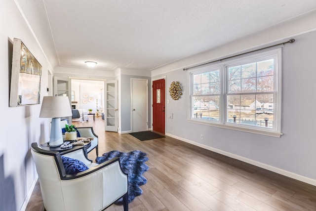 entryway featuring a textured ceiling, baseboards, and wood finished floors