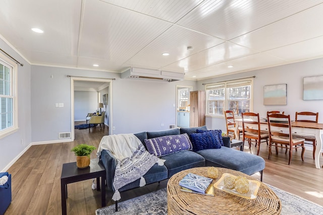 living area featuring baseboards, visible vents, ornamental molding, wood finished floors, and recessed lighting