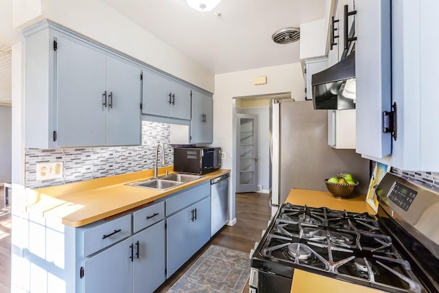 kitchen featuring extractor fan, stainless steel appliances, a sink, visible vents, and decorative backsplash