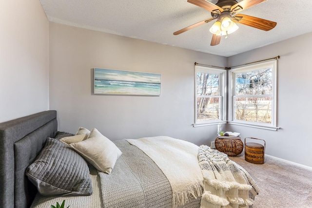 carpeted bedroom with ceiling fan, a textured ceiling, and baseboards