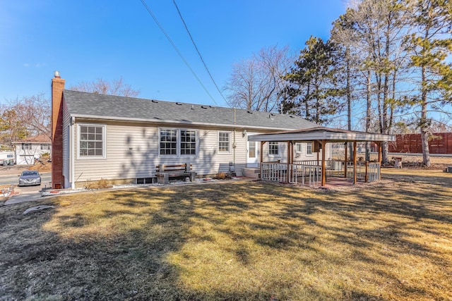 back of property with a lawn, a chimney, and fence