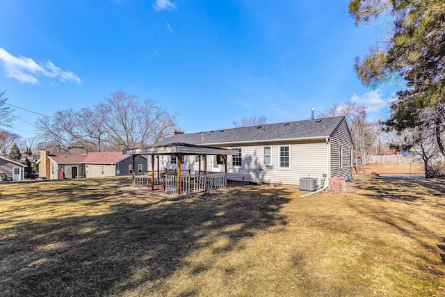 back of house with central AC and a lawn