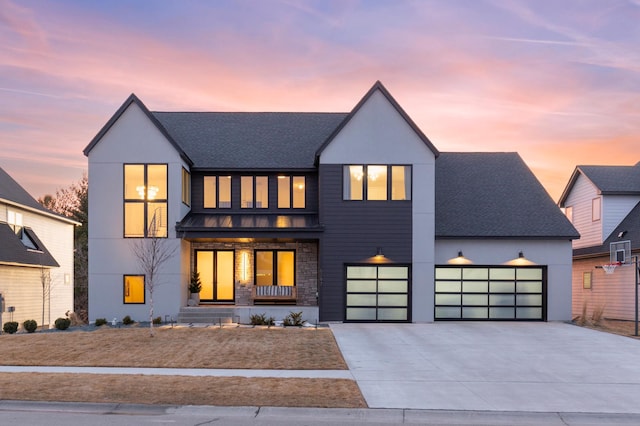 view of front of home featuring a garage, roof with shingles, concrete driveway, and a standing seam roof