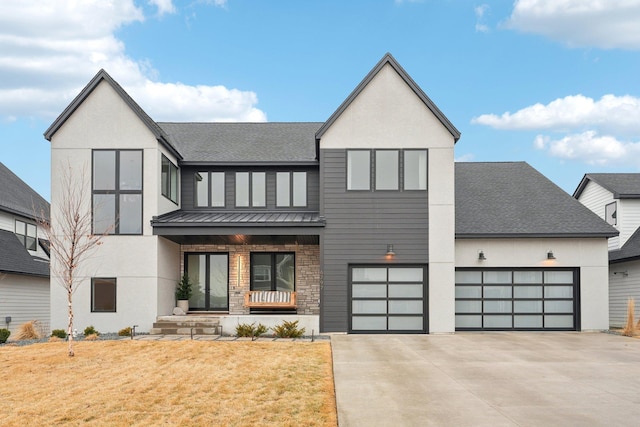 view of front of home with a standing seam roof, roof with shingles, concrete driveway, an attached garage, and metal roof