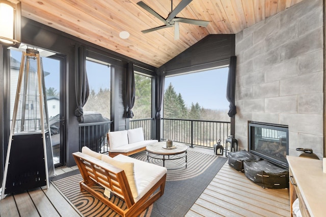 sunroom featuring a tiled fireplace, wood ceiling, ceiling fan, and vaulted ceiling