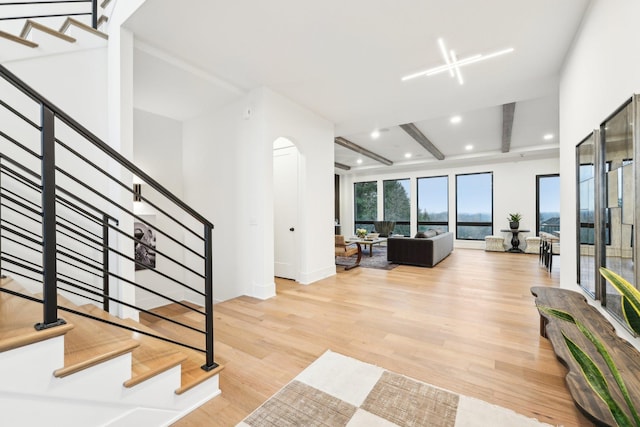 foyer featuring stairs, beamed ceiling, recessed lighting, and light wood finished floors