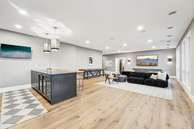 interior space with light wood finished floors, recessed lighting, baseboards, and decorative light fixtures