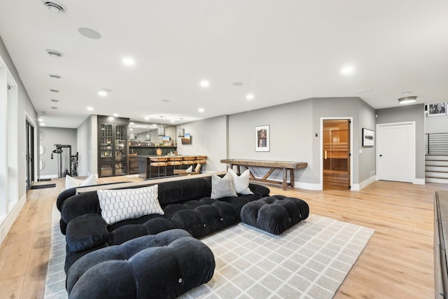 living room with recessed lighting, stairway, baseboards, and light wood finished floors