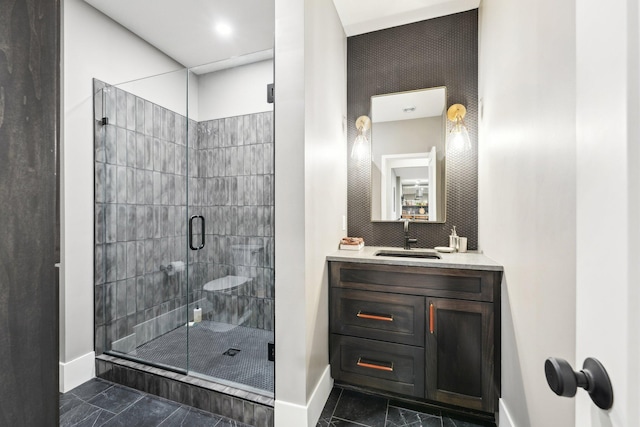 bathroom featuring a shower stall, vanity, and baseboards