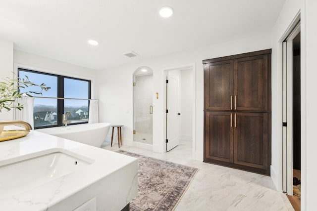 full bathroom featuring a freestanding tub, visible vents, marble finish floor, a stall shower, and recessed lighting