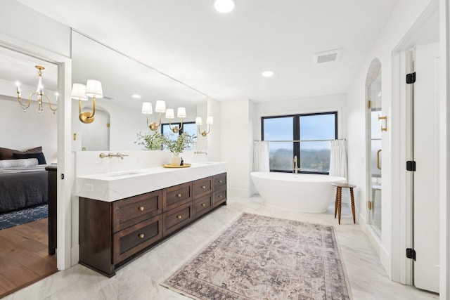 full bath with double vanity, visible vents, a soaking tub, and marble finish floor