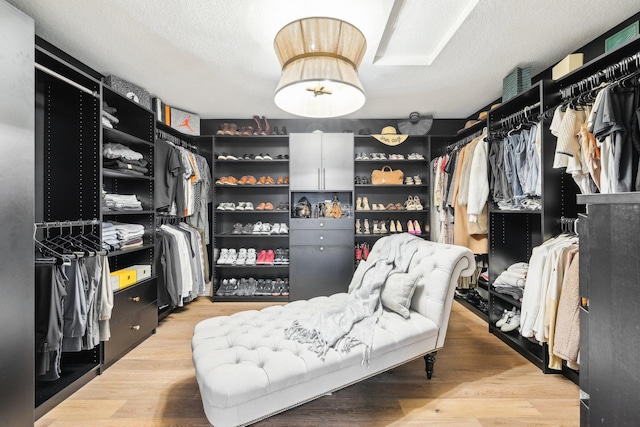 walk in closet with light wood-style floors