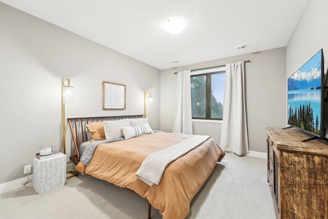 bedroom with a textured ceiling, baseboards, and light carpet