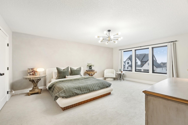 carpeted bedroom featuring an inviting chandelier, baseboards, and a textured ceiling