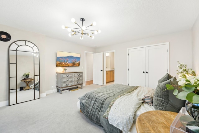 carpeted bedroom featuring baseboards, a closet, and a chandelier