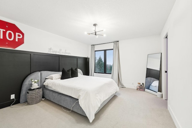 bedroom with baseboards, carpet floors, a notable chandelier, and a textured ceiling