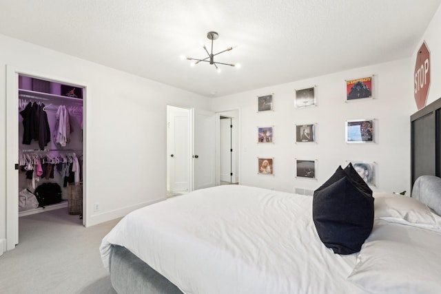 bedroom featuring an inviting chandelier, light colored carpet, a closet, and baseboards