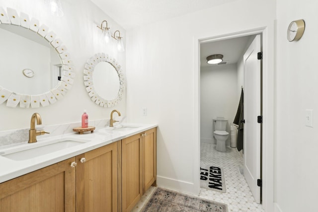 full bath featuring double vanity, toilet, baseboards, and a sink