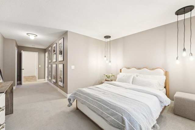 bedroom with baseboards and light carpet