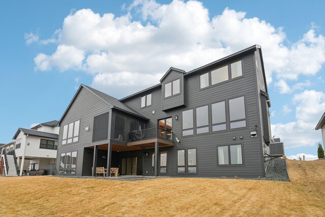 back of house featuring a patio, a yard, and a sunroom