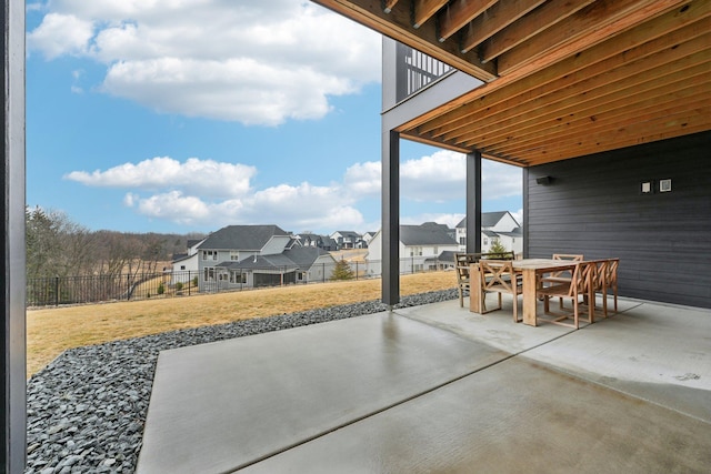 view of patio / terrace featuring outdoor dining space, a residential view, and fence